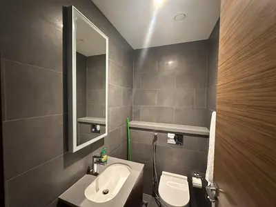 a bathroom with a sink and a toilet and a mirror at Stylish & Cozy Fully Furnished 2BR plus Maid Crest C in Dubai