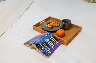 a tray with a plate of muffins and a cupcake and an orange at 2BR Duplex DIFC Near Museum of the Future in Dubai