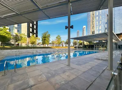 a swimming pool with chairs and a building at 2BR Duplex DIFC Near Museum of the Future in Dubai