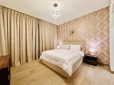 a bedroom with a bed and a large window at Greens Community View Spacious 1BR Fully Furnished in Dubai