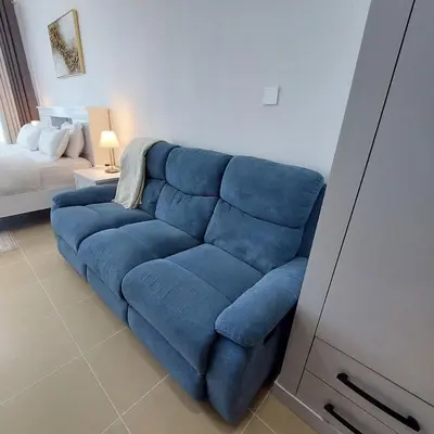 a blue couch in a living room with a bed at Modern 1BR Duplex Jumeirah Bay X1-1 In JLT in Dubai