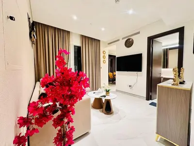a living room with red flowers in a room at Brand New 1BR in Creek Vista Grande in Dubai