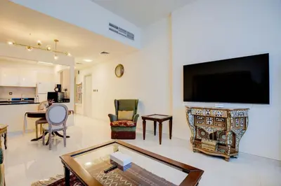 a living room with a flat screen tv on a wall at Elegant 1BR in Polo Residences Nad Al Sheba in Dubai