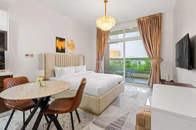 a hotel room with a bed and a table at Stylish Pool-View Studio w Balcony & King Bed in Dubai