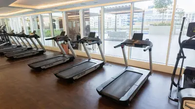 a row of treadmills in a gym at Stylish Pool-View Studio w Balcony & King Bed in Dubai