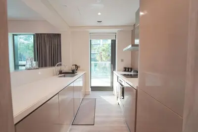 a white kitchen with a sink and a counter at Stylish 2BR Paramount Tower D in Dubai