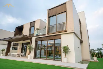 a house with large windows and green grass at New Arabian Palm Hills 6BR & Maid & Private Pool in Dubai