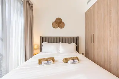 a bedroom with a large bed with two pillows on it at Bright & Stylish Home in the Heart of Meydan in Dubai
