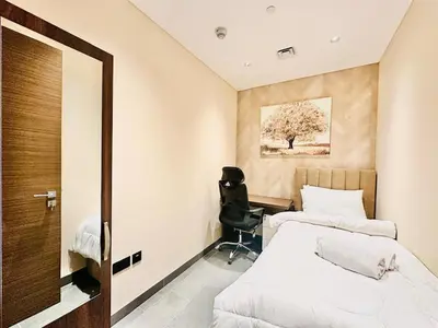 a bedroom with two beds and a chair in it at Modern Fully Furnished 1BR plus Study in Crest Tower B in Dubai