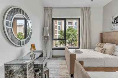 a bedroom with a bed and a mirror and a desk at GuestReady - Downtown stay | 29 Boulevard in Dubai
