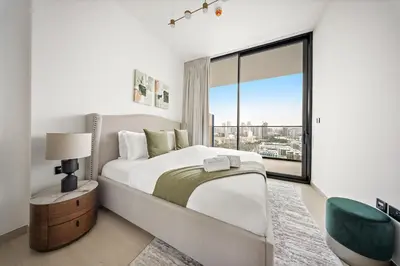 a bedroom with a large bed and a large window at FIRST CLASS 1BR Urban Living Comfort in Dubai