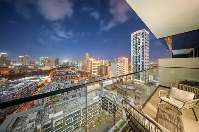 a balcony with a view of a city at night at FIRST CLASS 1BR Urban Living Comfort in Dubai