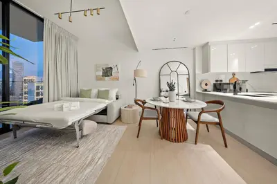 a living room with a bed a table and a kitchen at FIRST CLASS 1BR Urban Living Comfort in Dubai