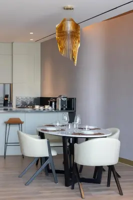 a dining room with a table and chairs and a chandelier at The Opus Residences Luxury Design in Dubai