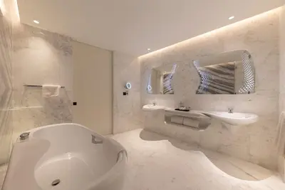 a white bathroom with a tub and a sink at The Opus Residences Luxury Design in Dubai