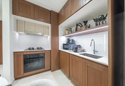 a kitchen with wooden cabinets and a sink at 1 Bed in Palace Beach Residence with sea view in Dubai
