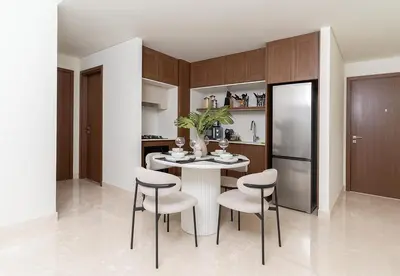 a kitchen with a table with chairs and a refrigerator at 1 Bed in Palace Beach Residence with sea view in Dubai