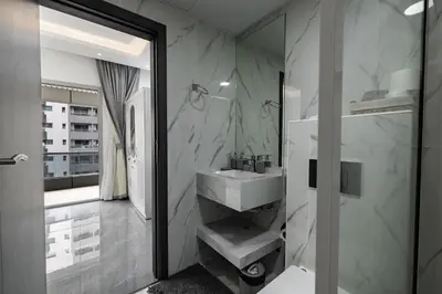a bathroom with a white sink and a shower at Dubai Marina - Comfy 1BHK Apartment in Dubai