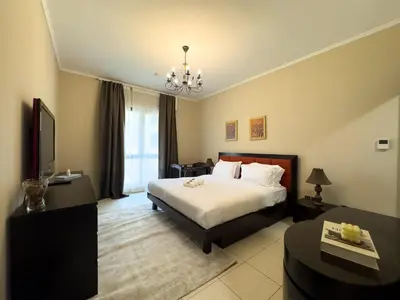 a hotel room with a bed and a television at Werova - Spacious 1-Bedroom Apartment for Rent in Dubai
