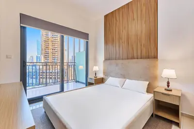a bedroom with a large bed and a large window at Compact 1 BHK Apartment in Dubai