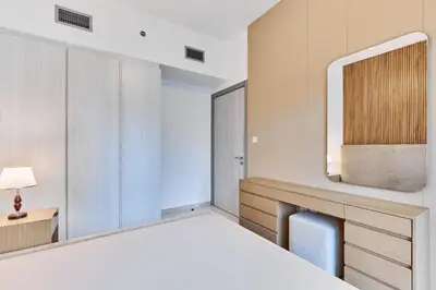 a bedroom with a bed and a desk and a mirror at Compact 1 BHK Apartment in Dubai