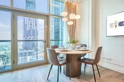 a dining room with a table and chairs and a large window at Stylish Studio in the Heart of DIFC in Dubai