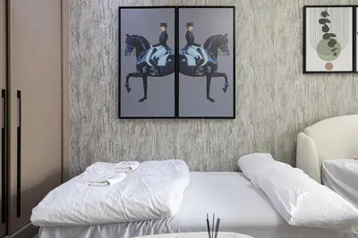 a room with a bed and a picture of two men on horses at Stylish Silicon Oasis Studio Near Mall & Airport in Dubai
