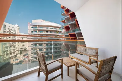 two chairs and a table on a balcony with a view at Stylish Silicon Oasis Studio Near Mall & Airport in Dubai