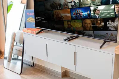 a tv sitting on top of a white entertainment center at Livin' Holidays -Studio - Azizi Magnificent Studio in Dubai