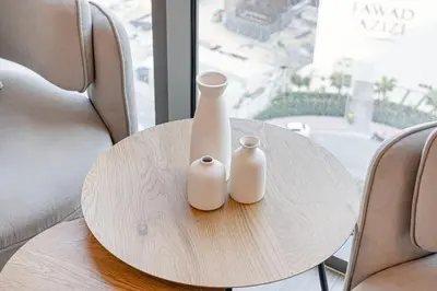 two white vases sitting on a table in front of a window at Livin' Holidays -Studio - Azizi Magnificent Studio in Dubai