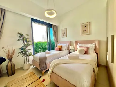 a bedroom with two beds and a window at SKYLiNE - 4 BR - BURJ KHALiFA & FOUNTAiN ViEW in Dubai