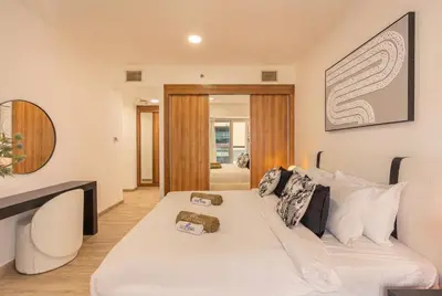 a living room with a white bed and a couch at Central Spacious Marina Home on the 64th Floor in Dubai