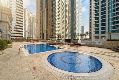 a large swimming pool in a city with tall buildings at Central Spacious Marina Home on the 64th Floor in Dubai