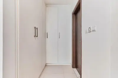 an empty corridor with white doors and a tile floor at Bright 2 BHK in Prime Location in Dubai