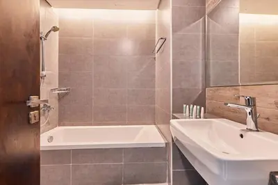 a bathroom with a white tub and a sink at Bright 2 BHK in Prime Location in Dubai