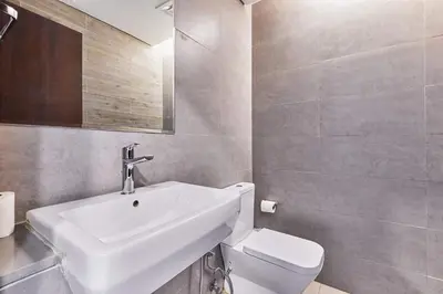 a bathroom with a white sink and a toilet at Bright 2 BHK in Prime Location in Dubai