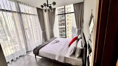 a bedroom with a bed and large windows at Elegant 1BHK Sea View Apartment City View in Dubai