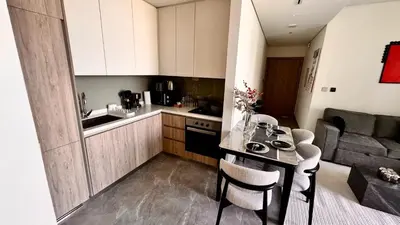 a kitchen with a table and chairs in a room at Elegant 1BHK Sea View Apartment City View in Dubai