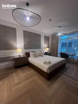 a bedroom with a bed and a desk and a table at bnbmehomes - Burj Views East Tower in Dubai