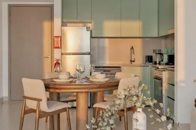 a kitchen with a wooden table and chairs in a kitchen at 1 Bedroom Apartment in Central Park, City Walk in Dubai