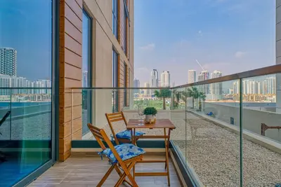 a balcony with a table and chairs and a view of the city at GuestReady - 1BR l Elegant City Escape in Dubai