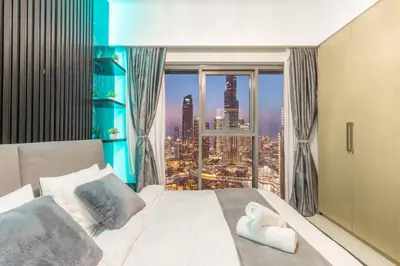 a bedroom with a large window with a city view at Elite Burj Khalifa Fountain 4 BR Flat in Dubai