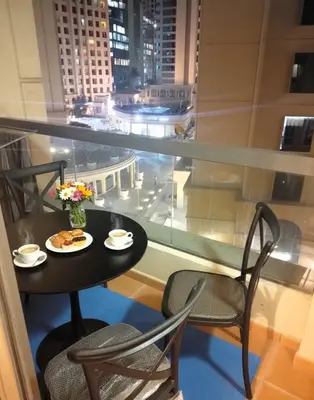 a table with a plate of food on a balcony at Dubai Short Stay Vacation Homes Rental Room in Dubai