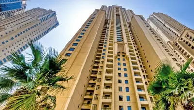 a tall building with palm trees in front of it at Dubai Short Stay Vacation Homes Rental Room in Dubai
