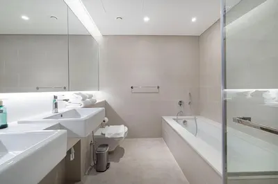 a bathroom with two sinks and a tub and a toilet at Serene Waterfront Gem UPSCALE in Dubai