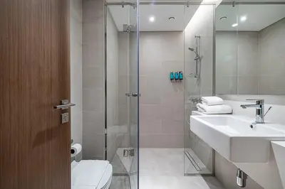 a bathroom with a shower and a sink and a toilet at Serene Waterfront Gem UPSCALE in Dubai
