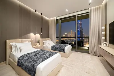 a bedroom with two beds and a large window at Paradise Retreats 3BR Burj Khalifa & Fountain view in Dubai