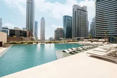 a large swimming pool in a city with tall buildings at Stunning Studio With Burj Khalifa & Canal Views in Dubai