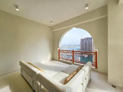 a living room with a couch and an arched window at Marina Residence 5, Palm Jumeirah - Mint Stay in Dubai