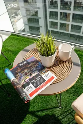 a table with a magazine and a cup of coffee at Airstay - Chic Studio in Meydan Azizi 65 - Monthly Offer Available in Dubai